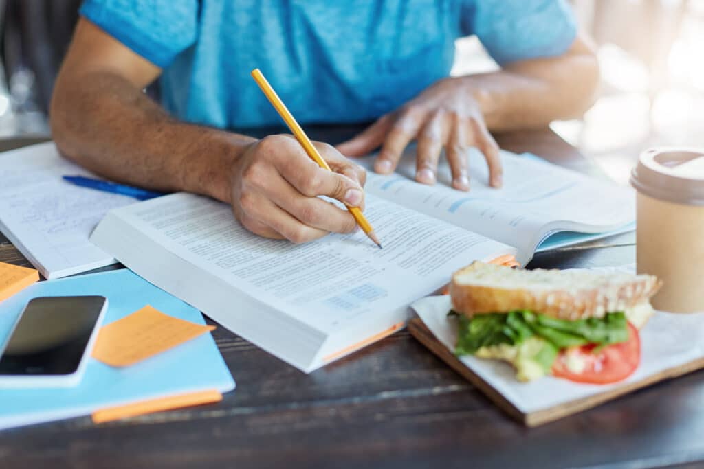 Male Student Highlighting Key Points in Order to Ace An Exam